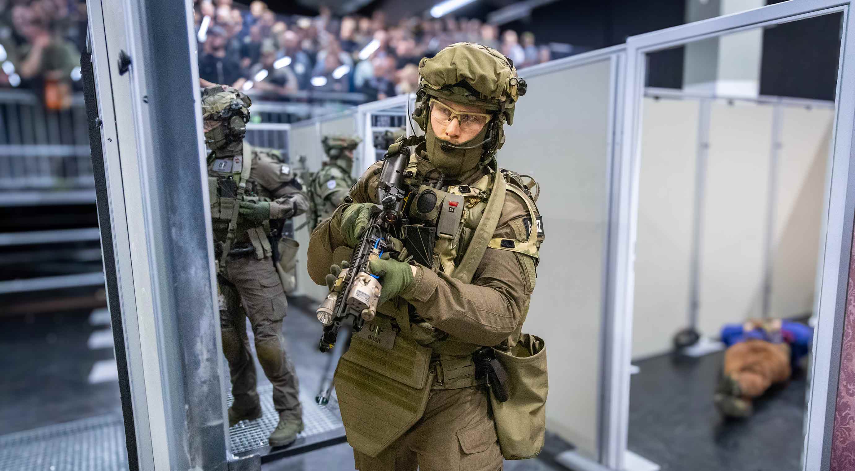 Armed soldiers in tactical gear at Enforce Tac Village during a live demonstration
